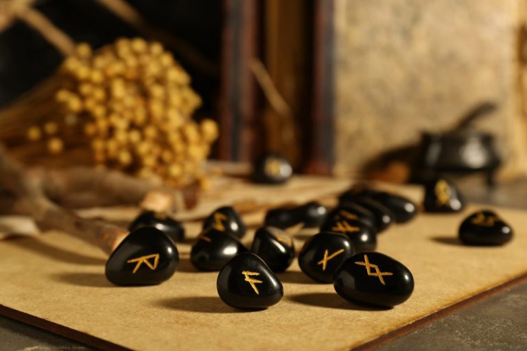 Pierres en bois gravées de runes nordiques, disposées sur une table en bois.